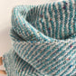 Close-up of a textured light aqua blue and gray woven fabric on a white background
