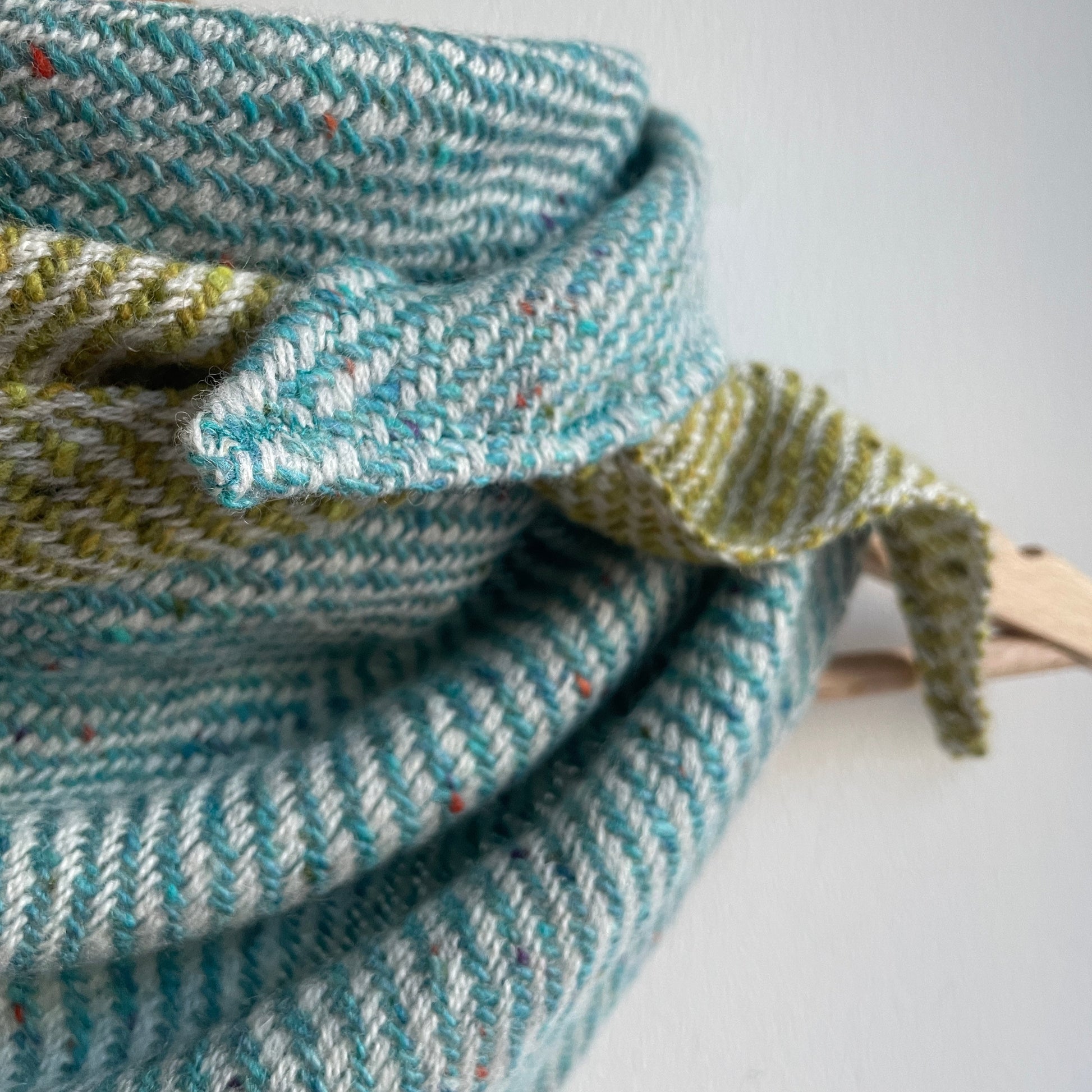 Woven fabric with blue and green pattern on a plain background
